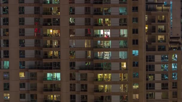 夜遅くの高層ビルの外観の窓は 時間経過とともに輝きと点滅するインテリアライトを備えています 空中展望 — ストック動画