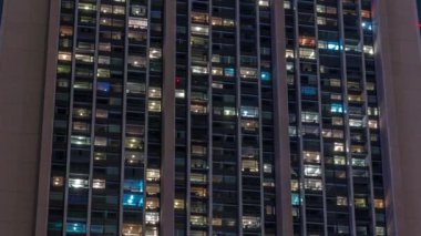 Modern ofiste büyük parlayan ve yanıp sönen pencereler ve konut binasının zaman çizelgesi geceleri, pencereler ışıldar..