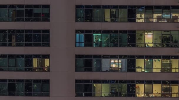 現代のアパートの窓のライトは夜にタイムラプスします 内部に照明付きの部屋があるマルチレベルの高層ビル — ストック動画