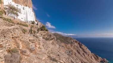 Panorama showing the famous white Hozoviotissa Monastery standing on a rock over the Aegean sea in Amorgos island timelapse hyperlapse, Cyclades, Greece.