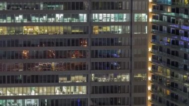 Geceleri ofis binalarının pencereleri, gökdelenlerin pencerelerinden gelen ışık. Parlak çalışma alanı olan şehrin akşam manzarası