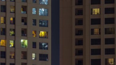 Dışarıdaki renkli binaların gece görüşü zaman ayarlı. Pencerelerinde parlayan ışıklar olan yüksek gökdelen