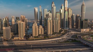 Dubai Marina highway intersection spaghetti junction morning . Tallest skyscrapers with reflection of sun on a glass surface. Aerial top view from JLT district during sunrise