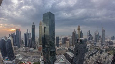 Panorama of futuristic skyscrapers with sunset in financial district business center in Dubai on Sheikh Zayed road . Aerial view from above with orange cloudy sky