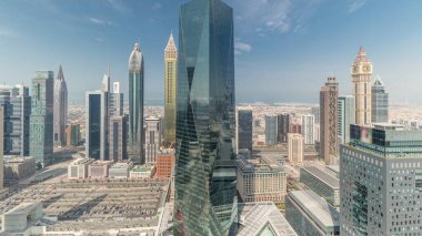 Panorama showing many futuristic skyscrapers in financial district business center in Dubai on Sheikh Zayed road . Aerial view from above with clouds