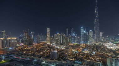 Panorama showing Dubai Downtown and business bay night  with tallest skyscraper and other illuminated towers view from the top in Dubai, United Arab Emirates.
