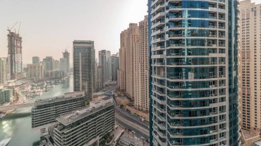 Panorama showing overview to JBR and Dubai Marina skyline with modern high rise skyscrapers waterfront living apartments aerial . Yachts floating on water of canal. JLT district on a background