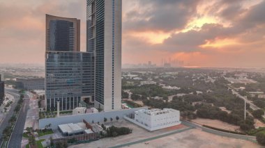 Sunrise in Dubai International Financial district transition . Aerial view of business office towers at morning. Skyscrapers with hotels near downtown