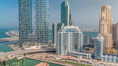 Promenade and canal seen from Dubai marina . Aerial view to JBR district and Bluewaters Island behind with hotels and skyscrapers.