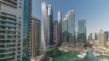 Panorama showing Dubai marina tallest skyscrapers and yachts in harbor aerial . View at apartment buildings, hotels and office blocks, modern residential development of UAE