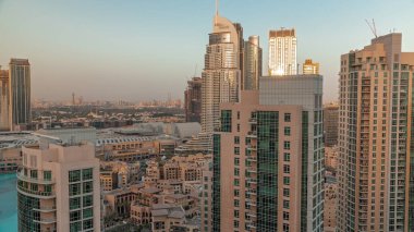 Aerial skyline of buildings in Downtown Dubai  during sunset. Shopping mall and traditional houses of old town. Skyscrapers in Deira district on a background