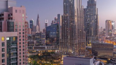 Aerial view of Dubai International Financial Centre district skyscrapers night to day transition  from downtown. Office towers from glass and hotels with modern buildings