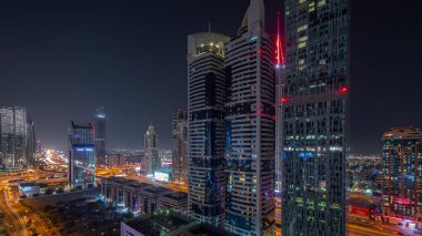 Aerial view of Dubai International Financial District with many skyscrapers night . Starry sky and illumination turning off. Dubai, UAE.