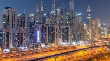 Dubai marinası gece gündüz en uzun gökdelen bloğu. JLT bölgesinden apartman binalarına, otellere ve otoyol yakınlarındaki iş kulelerine hava manzarası.