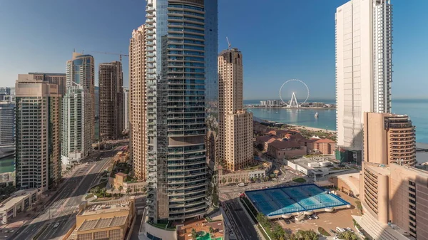 Panorama showing Dubai Marina and JBR area and the famous Ferris Wheel aerial  and golden sand beaches in the Persian Gulf at the morning