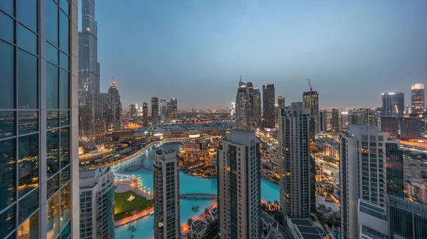 Dubai downtown with fountains and modern futuristic architecture aerial night to day transition  before sunrise. Panoramic view to skyscrapers with old town and shopping mall
