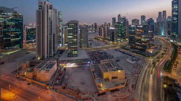 Business Bay Dubai skyscrapers with water canal aerial day to night transition panoramic . Mixed use development with residential and office towers sharing the footprint equally
