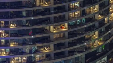 Gece vakti üst sınıf bir binanın pencerelerinin önünde oturuyorlardı. Gökdelende parlayan ışıklar ve balkonlar