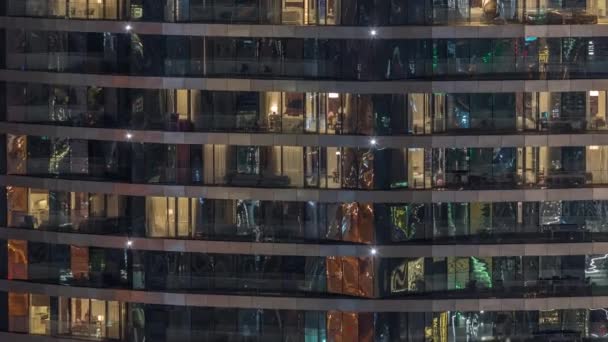 夜のタイムラプスで高級ビルのアパートの窓の外の景色 超高層ビルで黄色の光を放つ — ストック動画