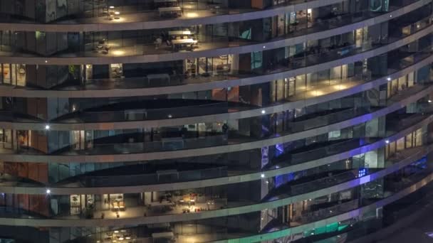 夜のタイムラプスで高級ビルのアパートの窓の外の景色 超高層ビルで光る光 バルコニーの椅子 — ストック動画