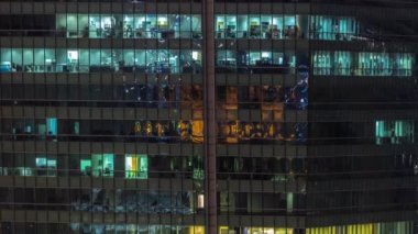 Modern ofis binalarında gece aydınlatmalı pencereler zaman ayarlı. Parlayan ışıkları olan çok katlı gökdelenler..