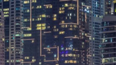 Çok katlı binaların panoramik pencerelerindeki gece görüşü hava zaman ayarlı. Büyük bir şehirde aydınlık bir gökdelen.
