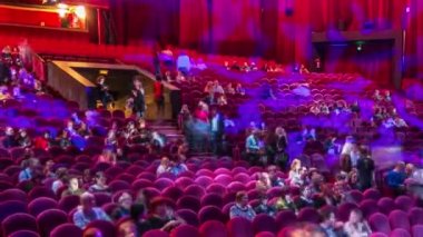 Seyirci toplantı salonunda toplamak ve tiyatro timelapse gösterisinde dikkat et. Kırmızı koltuk koltuk ile büyük salonu. Işığı kapat kadar yerleri doldurarak izleyiciler. Sol taraftan göster