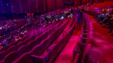 Seyirci toplantı salonunda toplamak ve tiyatro timelapse gösterisinde dikkat et. Kırmızı koltuk koltuk ile büyük salonu. Işığı kapat kadar yerleri doldurarak izleyiciler. Sağ taraftan göster