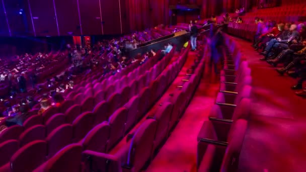 观众聚集在礼堂 Timelapse 剧院的演出 大大厅与红色扶手椅位子 观众在关闭灯之前填充位置 从右侧查看 — 图库视频影像