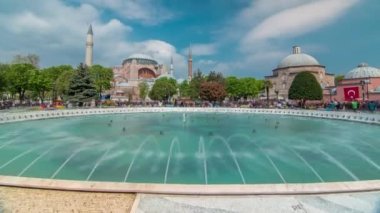 Hagia Sophia with a fountain timelapse, Christian patriarchal basilica, imperial mosque and now a museum, Istanbul, Turkey. Blue cloudy sky at spring day