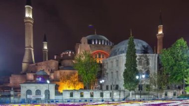 Illuminated Hagia Sophia with flowerbed timelapse - ancient orthodox temple in Istanbul on illuminated at twilight. Aya-Sofia famous landmark of byzantine architecture in Medieval Constantinople