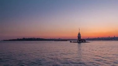 Maidens tower after sunset day to night transition timelapse in istanbul, turkey, kiz kulesi tower. Panoramic city skyline on background with reflection on Bosforus water