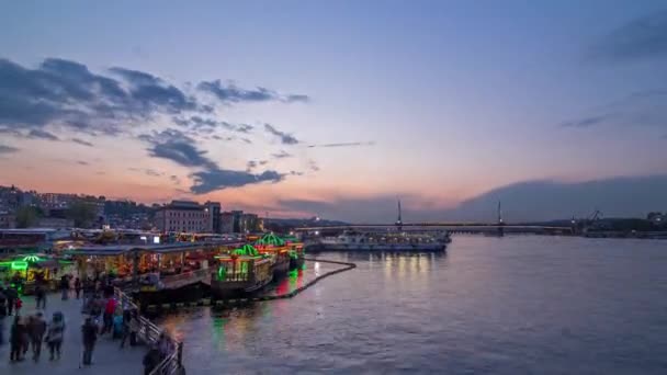 旅客フェリーは 日没から夜への移行時間経過 イスタンブールのスカイライン トルコの後にボスポラスのゴールデンホーンのボートステーションの近くにフェリー 水の反射と背景にモスクや橋 — ストック動画