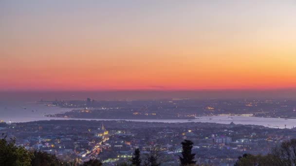 イスタンブールの夜のスカイラインの風景の日から夜への移行のタイムラプス Camlicaの丘からBosporusチャンネル上の空中ビュー 船とボスポラス海峡の青い水 道路上の交通 — ストック動画