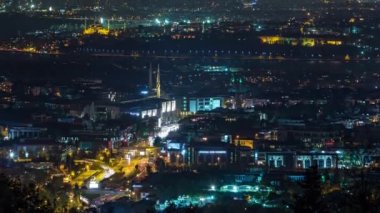 Istanbul night skyline scenery timelapse, view over Bosporus channel from Camlica hill. Marmara University Vocational School of Theology. Blue water of Bosporus channel with ship. Traffic on roads