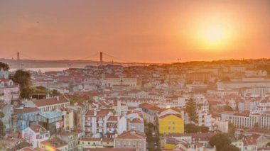 Lizbon gün batımında şehir merkezinin panoramik manzarasında güz akşamında kırmızı çatılar, Portekiz. Sophia de Mello Breyner Andresen 'in bakış açısı. Turuncu gökyüzünde güneş