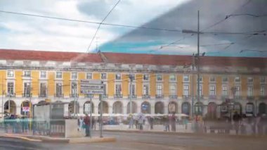Lisbon old tram stops on the Commerce Square in old town timelapse. Famous vintage tourist travel attraction. Colorful architecture city buildings street scene in downtown