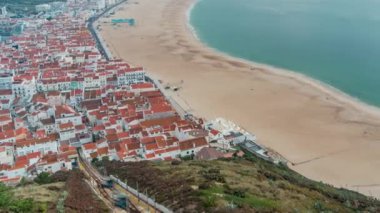 Nazare panorama with cabins of Funicular timelapse. Fog coming from ocean at evening during sunset. The most popular seaside resorts in Atlantic coast. Skyline and beach waterfront. Portugal