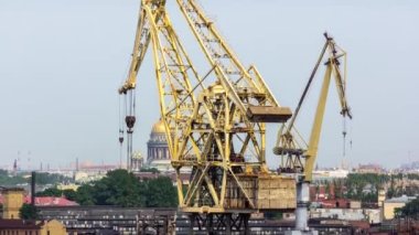 Working yellow cranes at shipyard aerial timelapse. Blue clear sky on a background