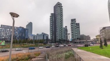 Parktaki gökdelenleri ve biblioteka 'yı gösteren panorama yeşil çimenlik zaman ayarlı. Piazza Gae Aulenti ve Isola arasında yer almaktadır. Yol kavşağında trafik vardı. Milan mı? İtalya