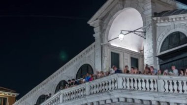 Rialto Köprüsü 'nün tepesinde ya da Ponte di Rialto' da Venedik, İtalya 'daki Büyük Kanal zamanlarında. İnsanlar sokak lambasının altında çitlerin yanında kalıyor.