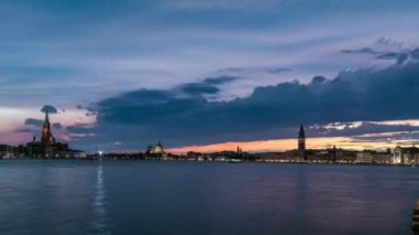 Basilica Santa Maria della Salute. San Giorgio Maggiore Island and San Marco square day to night transition timelapse, Venezia, Venice, Italy. Colorful cloudy sky. Evening illumination