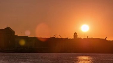 Beautiful sunrise at Grand canal over San Marco square timelapse. View from Church of Santa Maria della Salute, Venice, Italy, European Union. Reflection on water and orange sky