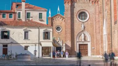 Entrance to Basilica di Santa Maria Gloriosa dei Frari timelapse and narrow street. This old famous church was built in the 14th century and is a tourist attraction. Blue sky at summet day. Venice