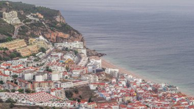 Atlantik Okyanusu 'nun ortasındaki Susimbra Köyü' nün kıyı şeridinin hava görüntüsü. Kale 'nin bakış açısından aydınlatılmış evlerle dolu bir akşam. Portekiz