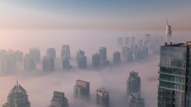 Güneş doğduktan sonra Şeyh Zayed Yolu yakınlarındaki JLT gökdelenleri ve marina kulelerini sis kapladı. Konut binası sisli bir sabah ve sıcak turuncu ışık