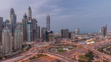 Panorama of Dubai Marina and media city highway intersection spaghetti junction night after sunset. Illuminated tallest skyscrapers on a background. Aerial top view from JLT district.