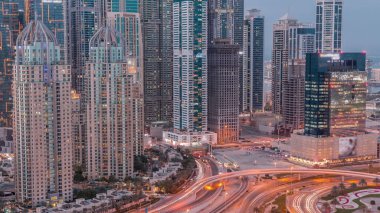 Dubai Marina 'nın gökdelenleri gün batımından gece saatlerine kadar aydınlatılmış en yüksek konut binaları. Otoyol kavşağı olan JLT bölgesinin hava üst görüntüsü