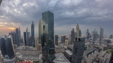 Sheikh Zayed karayolu zaman çizelgesinde Dubai 'deki finans merkezinde gün batımına sahip gelecekçi gökdelenlerin manzarası. Yukarıdan gökyüzü turuncu bulutlu
