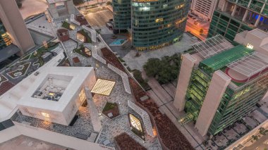 Kapı bulvarında gezinti ve Dubai uluslararası finans merkezi gökdelenleri caminin gece gündüz geçiş zamanı. Aydınlatılmış kuleler güneş doğmadan önce yukarıdan görünür